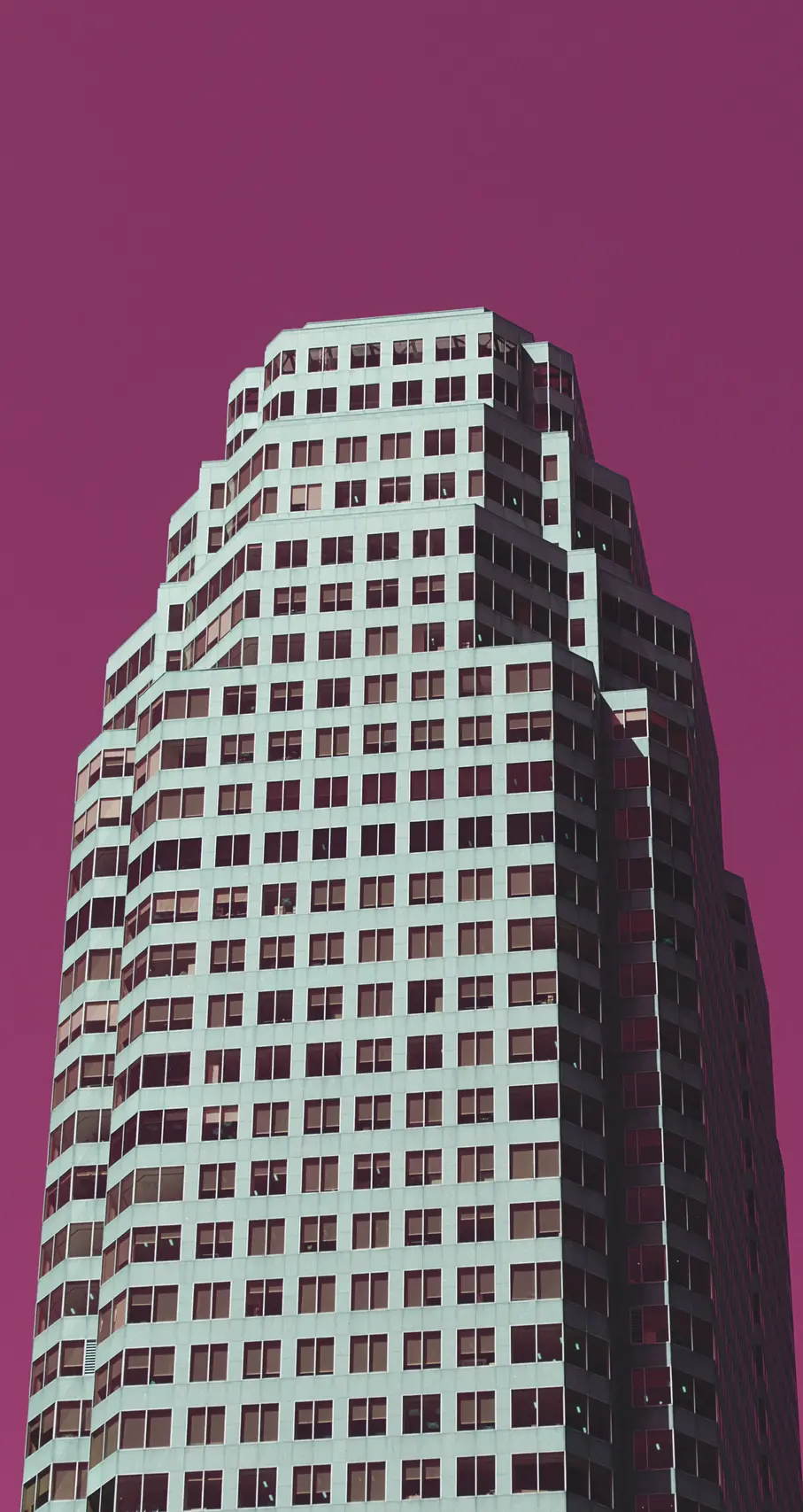 Shot of the Bay Wellington Tower in Toronto, CA with the sky turned to a cranberry red.
